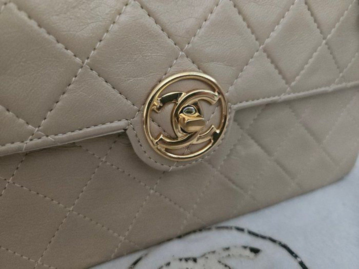 Chanel beige quilted leather flap bag with gold hardware and interlocking CC turn-lock closure.