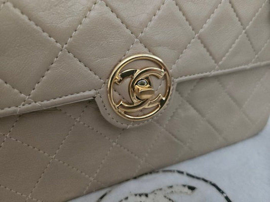 Chanel beige quilted leather flap bag with gold hardware and interlocking CC turn-lock closure.