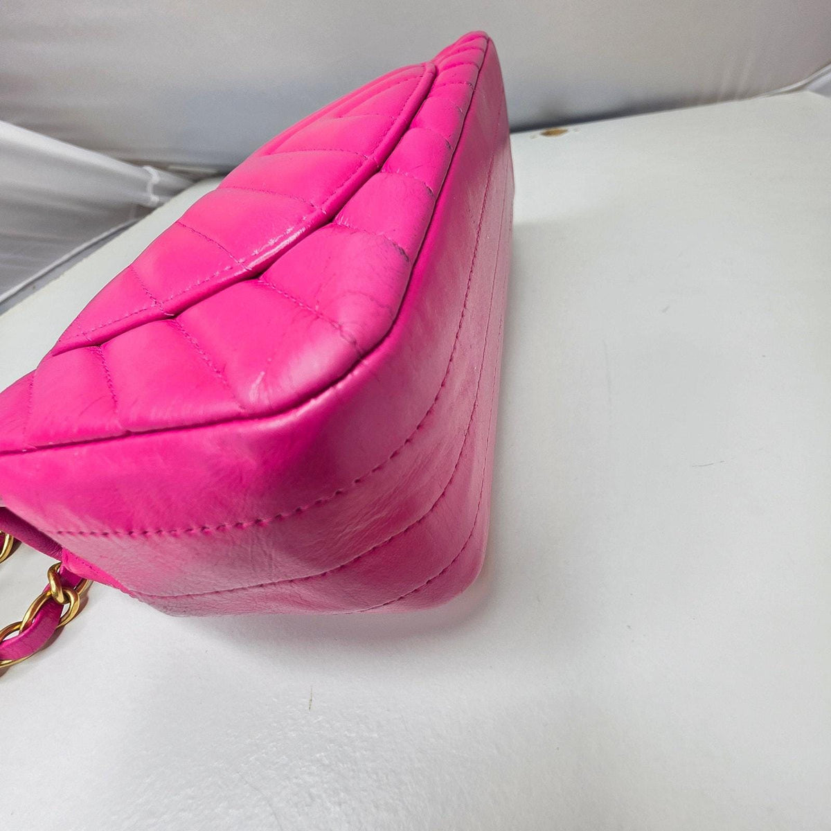 Chanel pink mini messenger bag in chevron leather with gold CC clasp and hardware.