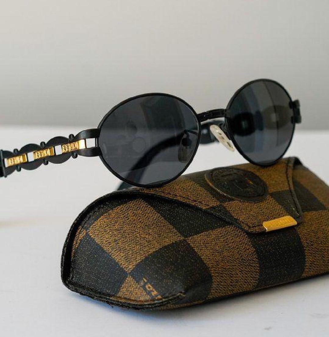 Fendi black and gold sunglasses with logo detail, high-quality plastic and metal frame.