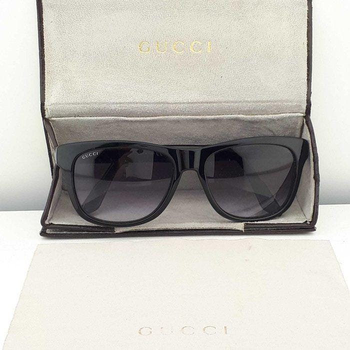 Gucci black Wayfarer sunglasses with grey gradient lenses and red-green striped temples.