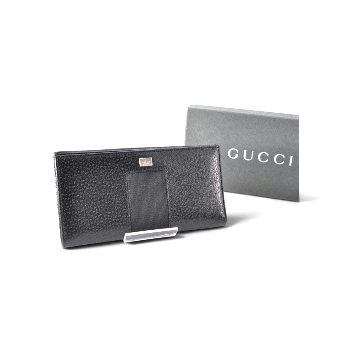 Gucci black leather zip around wallet with gold tone hardware and minimalist design.