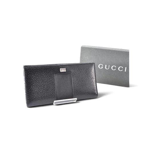 Gucci black leather zip around wallet with gold tone hardware and minimalist design.