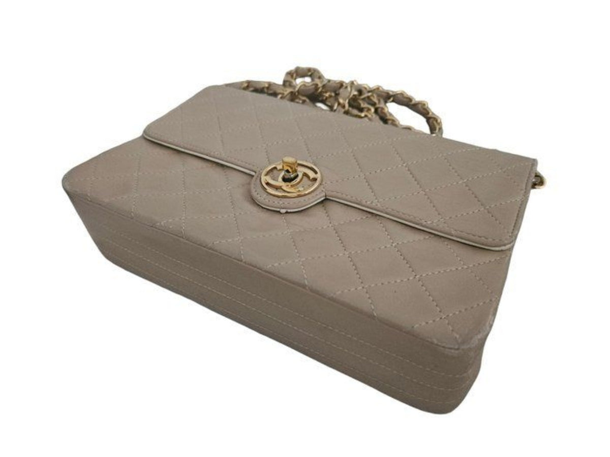 Chanel beige quilted leather flap bag with gold hardware and interlocking CC turn-lock.