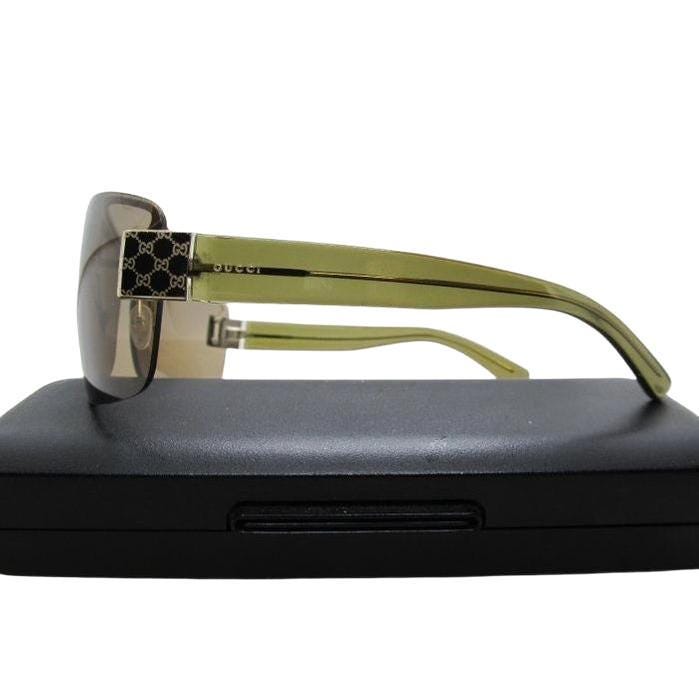 Gucci half-rim wrap sunglasses in green and gold, featuring vintage design and logo.