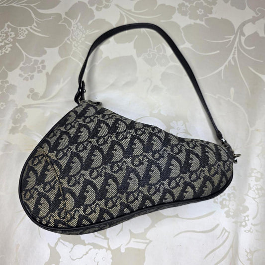 Dior messenger bag in grey, blue, and black with silver accents and saddle shape.