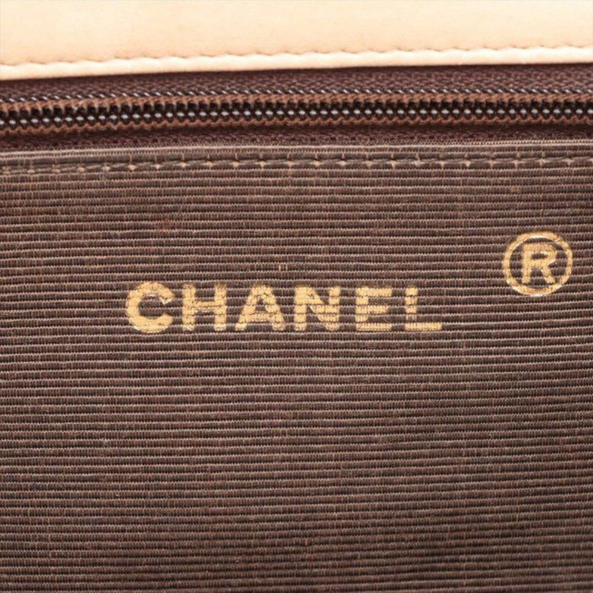 CHANEL beige matelassé leather half moon shoulder bag with gold hardware and classic logo.