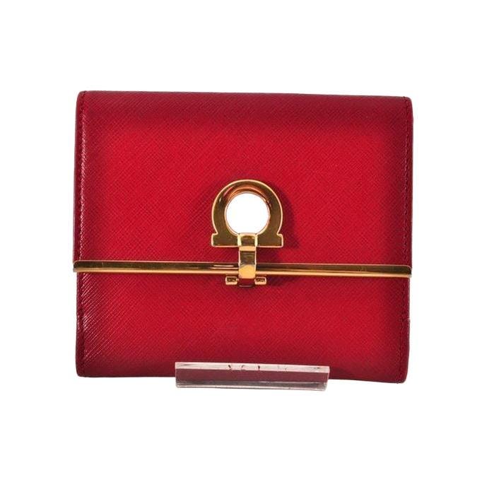 Salvatore Ferragamo red leather wallet with gold hardware and organized interior.