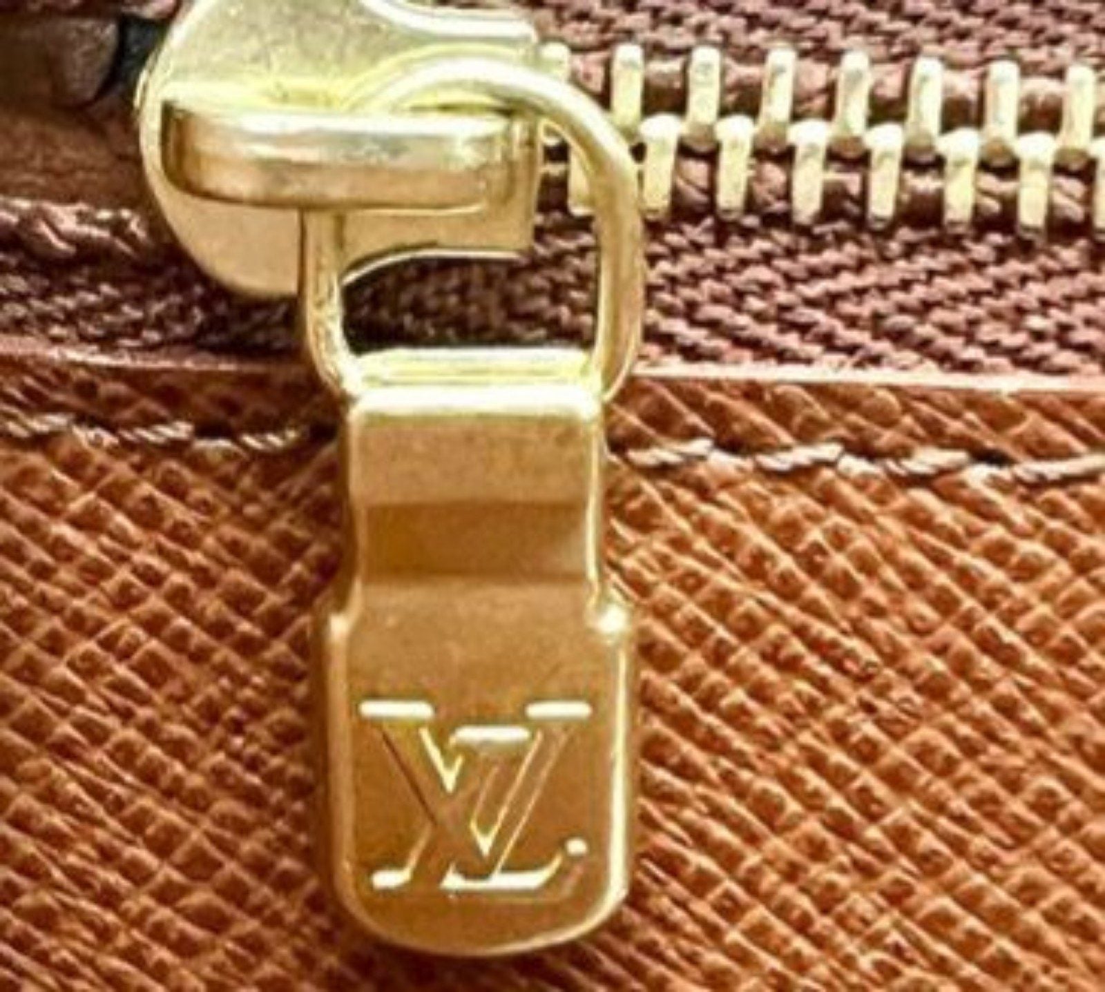 Louis Vuitton brown Epi leather pochette bag with gold hardware and textured finish.